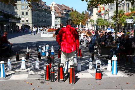 Bern, Switzerland - 24 September 2017: Chess game between two men on a chessboard painted on the pavement. Observers of this game are also interested.のeditorial素材