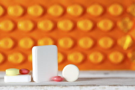 The dose of tablets is seen against the background of pills in blister packs.の写真素材