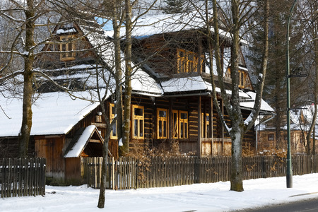 Zakopane, Poland - March 21, 2018: Behind the trees and the wooden fence there is a wooden villa locally called Koszysta. This historic building dates back to 1902.のeditorial素材