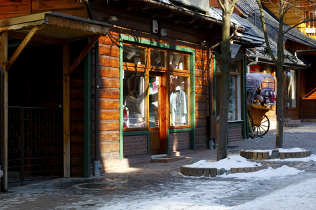 Zakopane, Poland - March 22, 2018: Shop window with clothes on sale visible inside. It is in a wooden building, which is located by the Krupowki street, which is the main shopping street in the city.のeditorial素材