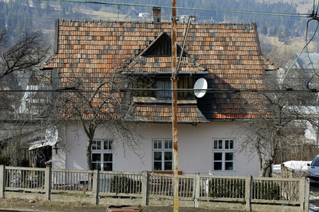 Zakopane, Poland - March 23, 2018: A building with a steep roof, which was covered with ceramic tiles. This house behind the concrete fence can be seenのeditorial素材