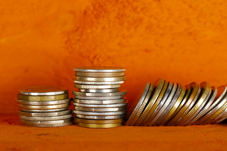 There are two stacks of coins and the third stack is overturnedの写真素材