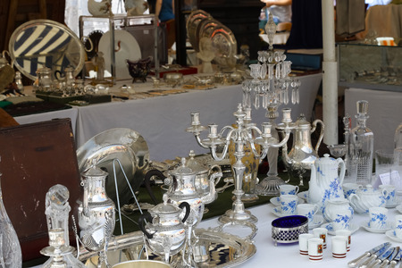 Nice, France - 17 September 2018: Candlestick and other silver items can be seen at the flea market in Cours Saleya, the famous city market offering antiques and many other products.のeditorial素材