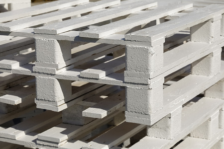Wooden pallets painted white can be seen from close up.
