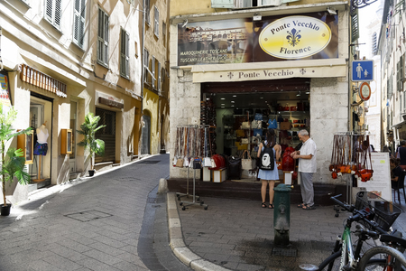 Nice, France - September 19, 2018: A store window with leather goods, in front of which two people stopped. There are two narrow streets on both sides of the shopのeditorial素材