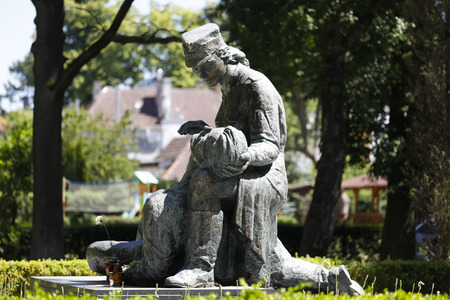 Kolobrzeg, Poland - June 08, 2018: The statue of a female nurse taking care of a wounded soldier is a tribute to women who fought for freedom in the ranks of the Polish Army during WW II.のeditorial素材