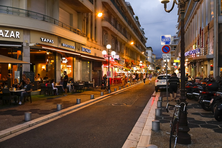 Nice, France - September 23, 2018: Night view along a street with various shops, whose stands are located on the sidewalk and cafes are often also outdoor cafes. People are thereのeditorial素材