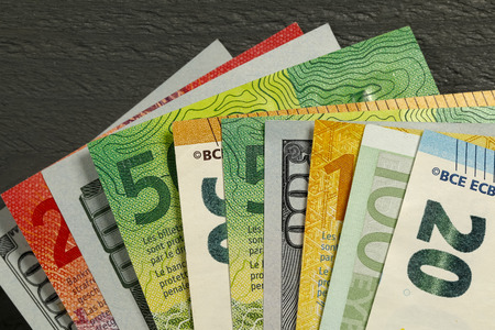 A variety of paper money forms the financial backdrop. There are various banknotes of different...
