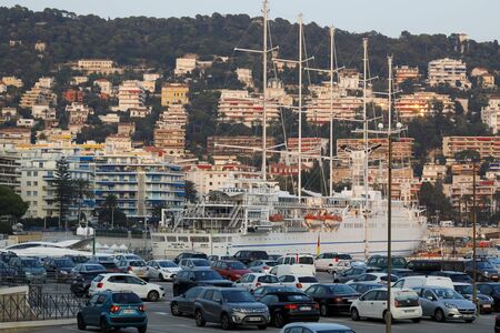 Nice, France - September 20, 2018: A little further on the hill there are residential buildings painted with evening light and there is a large car park and parked cars.のeditorial素材