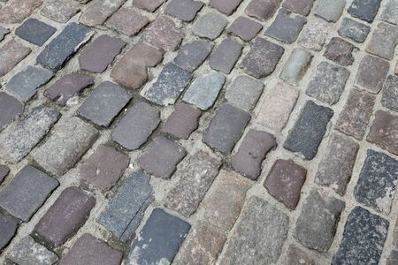 The surface of cobbled street is seen on one of the streets of the old town of Warsaw in Poland.