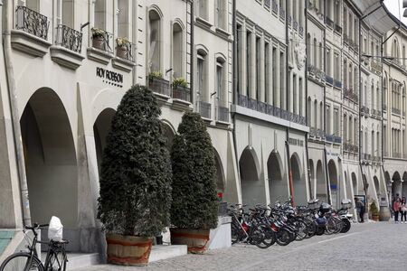 Bern, Switzerland - April 16, 2019: Townhouses with stone facades, cobbled street of the old town...