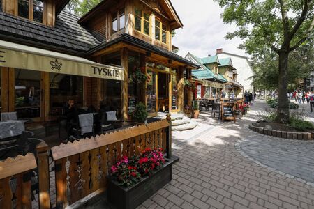 Zakopane, Poland - July 10, 2019: The exterior view of a wooden building on Krupowki Street. It is here that the restaurant called Karczma Bacowka is located.のeditorial素材
