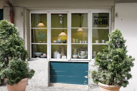 Bern, Switzerland - April 16, 2018: Small boutique shop window by the street in the old town. There are objects and luminous lamps in the window.のeditorial素材