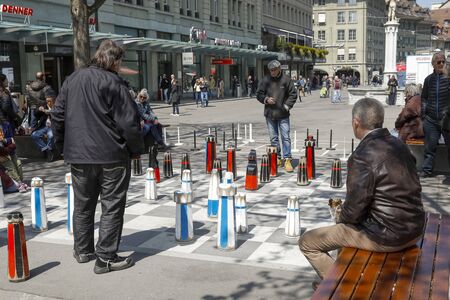 Bern, Switzerland - April 15, 2019: A game of chess between two men. The chessboard was painted on...