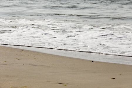 A gentle wave of the Baltic Sea reached the sandy beach, here in Kolobrzeg in Poland