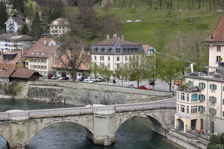 Bern, Switzerland - April 16, 2018: A district of the old town with a stone bridge over the river...