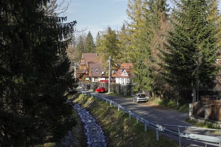 Zakopane, Poland - November 12, 2018: Among the trees there is a street, which is led along the brook locally called Bystra. There are houses in the residential area that look like hidden in a forest.のeditorial素材