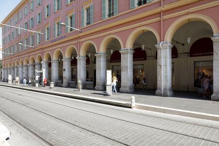 Nice, France - September 20, 2018: The arcades and their colonnade are part of one of the large urban buildings on Massena Square. Tram tracks and platform are right next to this building.のeditorial素材