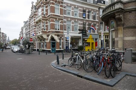 The Hague, The Netherlands - October 07, 2019: Crossroads of narrow streets in the old part of the city. On one of the corners of the crossroads there is a lot of bicycles parked.のeditorial素材
