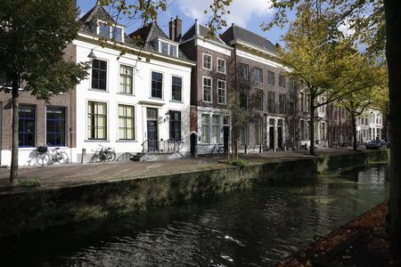 Delft, The Netherlands - October 10, 2019: Here is the shipping canal along which city buildings can be seen. Trees grow along this canal as well.のeditorial素材