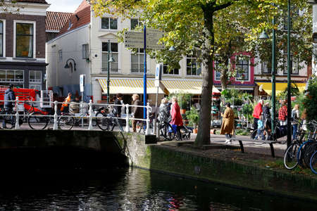 Delft, The Netherlands - October 10, 2019: Right next to the houses there is an inland waterway. There is also a stone bridge connecting the banks of the canal.のeditorial素材