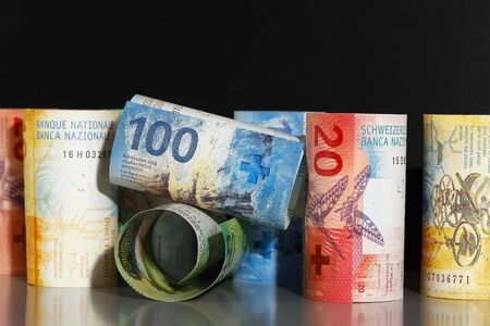 Here are rolled-up Swiss banknotes. This is the concept and idea to present the economy.の写真素材