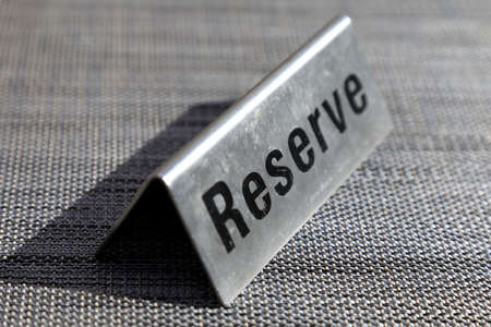 The metal plaque with the inscription Reserve on it is on an empty table.