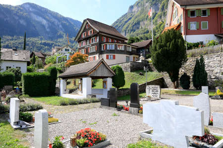 Bauen, Switzerland - August 27, 2020: A small cemetery is situated in a small village. In the background there is a mountain slope.のeditorial素材