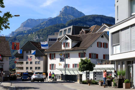 Brunnen, Switzerland - August 26, 2020: Residential houses by the street as seen during sunny day. There are several people walking around.のeditorial素材