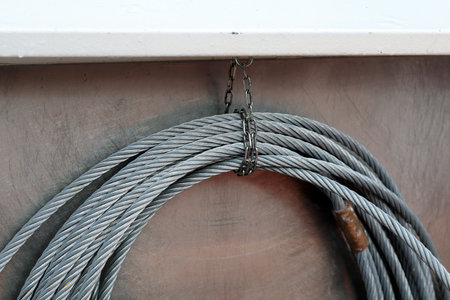 Steel rope hang coiled on the inside of the ship's side.