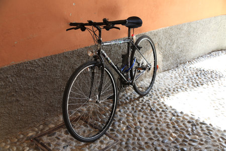 Bellagio, Italy - July 11, 2009: The bike has been parked at the wall of the building in a narrow street. The street is an old cobbled street.のeditorial素材