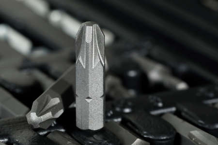 Replaceable tool tip. This replaceable screwdriver bit is visible against a blurred toolkit.