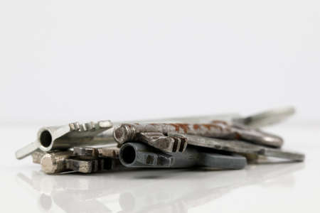 Some old door keys. Old and no longer needed keys have been stacked up and are seen against a bright background.の写真素材