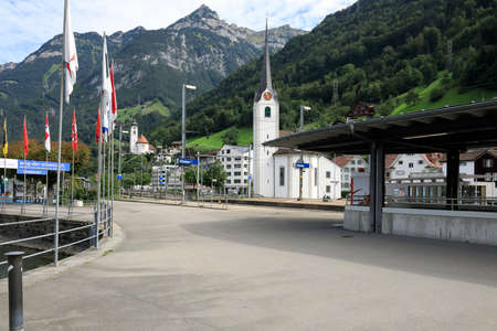 Fluelen, Switzerland - August 25, 2020: Town landscape with two churches. In the background you can see an alpine range of mountains, both rocky and covered with forest.のeditorial素材