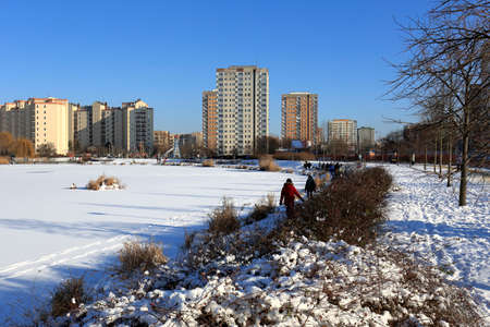 Warsaw, Poland - January 31, 2021: The parkland and the lake form part of a residential area called locally called Goclaw which can be seen here during a sunny winter day.のeditorial素材