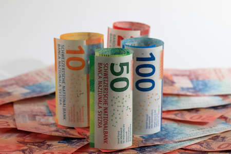 Swiss money. Swiss franc banknotes have been rolled up and placed side by side. CHF currency.の写真素材
