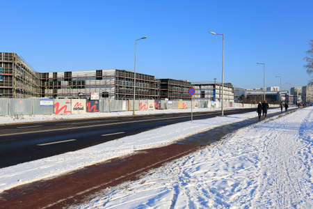 Warsaw, Poland - January 31, 2021: City street, sidewalk and snow-covered nearby land. Here on the housing estate Goclaw in winter the construction of the school continues.のeditorial素材