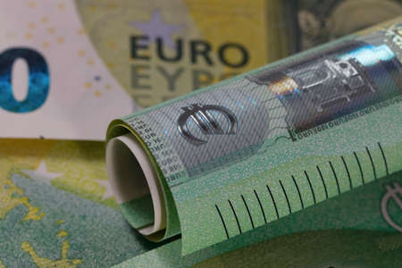 The Euro banknote has been rolled into a roll and shows the symbol of the euro. Euro banknotes are not made of paper, but of pure cotton fiber to improve their durability.の写真素材