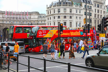 London, United Kingdom - June 5, 2010: There are two red buses and cars, and people on the city streets that look like a traffic jam.のeditorial素材