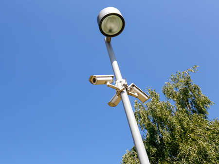 A surveillance cameras designed to observe the area were mounted on a street lamp poleの写真素材