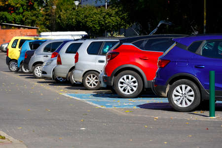 Warsaw, Poland - October 7, 2021: Closeup of right rear side of red car with other various cars parked in a row in outdoor parking lot during a sunny day.のeditorial素材