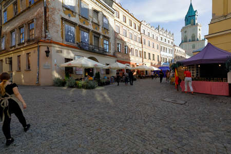 Lublin, Poland - September 10, 2021: On the paved sidewalk, near the old town houses, there are outdoor restaurants and stalls that can be seen here on a coming evening.のeditorial素材