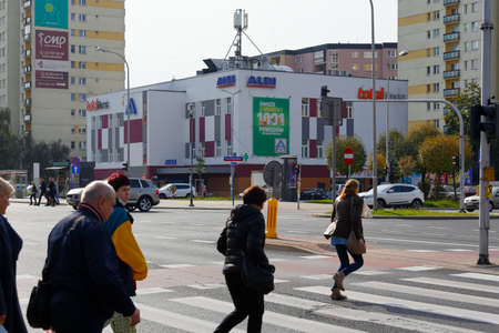 Warsaw, Poland - October 6, 2021: General view in the Goclaw district which shows the intersection and the pedestrian crossing where people cross the street. There are also various buildings here.のeditorial素材