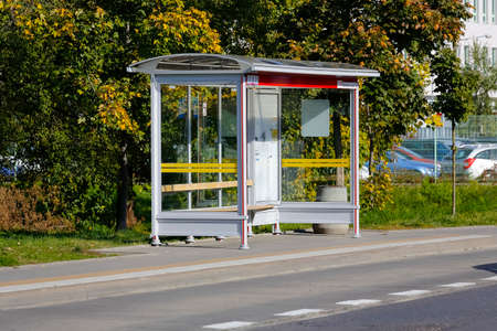 Warsaw, Poland - October 11, 2021: Vacant bus stop is located on the city streets in the Goclaw estate. There are trees behind the stop.のeditorial素材
