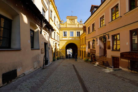 Lublin, Poland - September 11, 2021: Old Town Gate and a paved trail leading towards it. There are houses on both sides of the city walkway.のeditorial素材