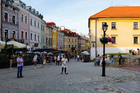 Lublin, Poland - September 11, 2021: Cobbled street of the old town with colorful townhouses and outdoor restaurants. There are people visiting this place in the cityのeditorial素材