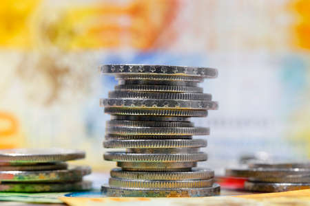Swiss franc coins stacked in piles and placed side by side against a background of banknotes are now the backdrop for various financial matters. CHF currency.の写真素材