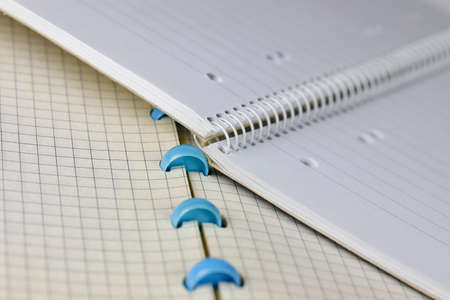 The lined notebook lies on the squared notebook, both are open and there are no notes on their pagesの写真素材