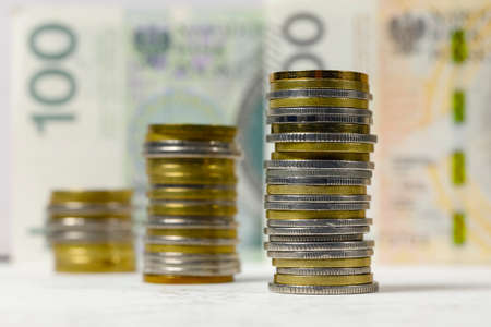 A group of Polish coins arranged next to each other against the background of banknotes, PLN currency, Polish zlotyの写真素材