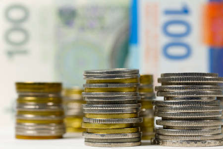 Swiss and Polish money. Coins of the Polish zloty and Swiss franc were placed next to each other against background of Polish and Swiss banknotes. PLN and CHF currenciesの写真素材